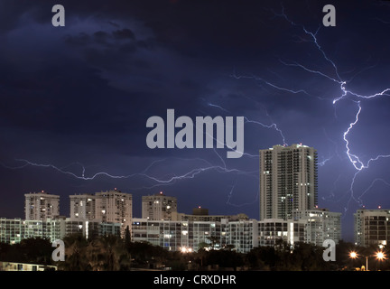 Scène de nuit de la ville urbaine avec grand éclair illuminant le ciel nuageux ciel d'orage. Banque D'Images
