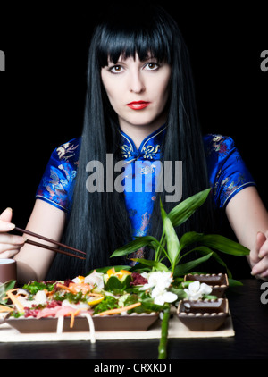 Fille aux cheveux noirs avec un restaurant baguettes au Japon Banque D'Images
