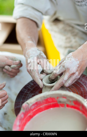 Mains d'un potier, la création d'un pot en terre sur le cercle Banque D'Images