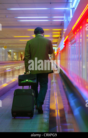 Un homme dans un couloir de Muenchen airport sur un escalator Banque D'Images