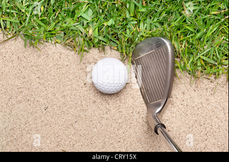 Une balle de golf dans une fosse de sable prêt à être frappé avec un fer à repasser. Banque D'Images