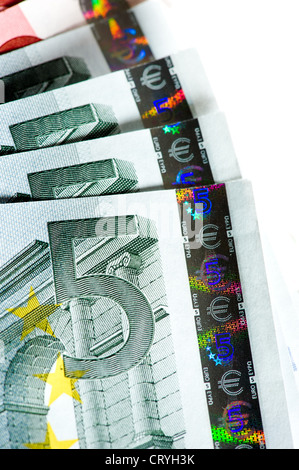 Gros plan de la dénomination et de l'hologramme de sécurité sur une pile ouverte de 5 billets en euros sur fond blanc. Banque D'Images
