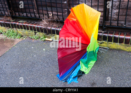 Un parapluie à l'envers et soufflé abandonné sur la chaussée après une tempête. Banque D'Images