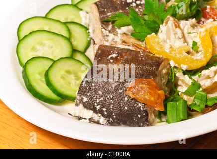 Thème de la mer. Rose saumon cuit dans la crème avec des légumes verts et sur plaque blanche, photo gros plan Banque D'Images