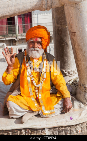 Indian Hindu Sadhu, saint homme, habillé en robe safran typique turban orange et donner une bénédiction à Jagdish Temple à Udaipur, Rajasthan, Inde Banque D'Images