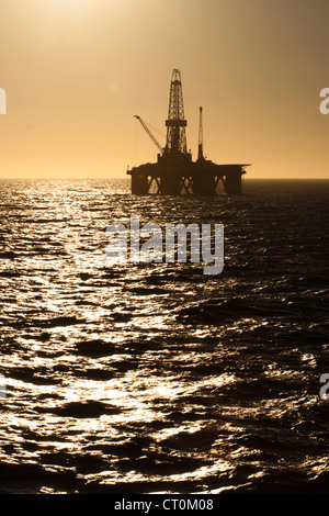 Silhouette d'offshore oil drilling rig au moment de coucher de soleil. Côte de l'état de Rio de Janeiro, le sud-est du Brésil. Banque D'Images