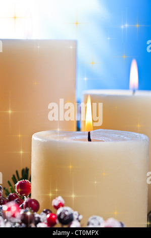 Trois chandelles dans un arrangement floral de l'avent pour l'avent et Noël avec étoiles d'or Banque D'Images