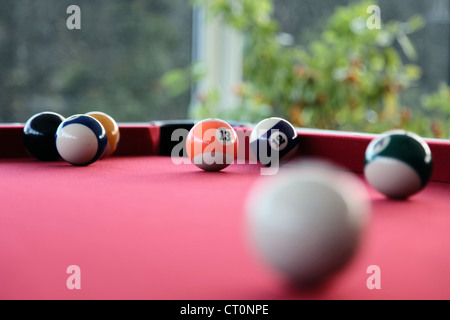 C'est une photo d'un snooker ou billard avec un tapis rouge et quelques billes sur elle. C'est un jeu amusant à jouer dans les bars ou à la maison Banque D'Images