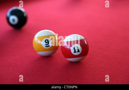 C'est une photo d'un snooker ou billard avec un tapis rouge et quelques billes sur elle. C'est un jeu amusant à jouer dans les bars ou à la maison Banque D'Images