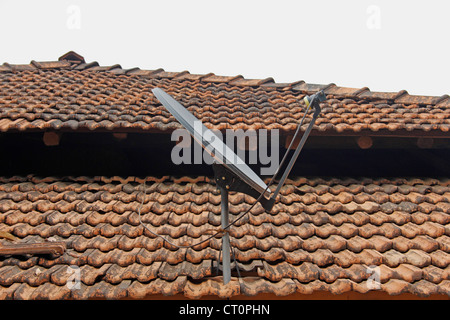 Une antenne parabolique d'un poste de télévision traditionnel sur un toit en pente fait Manglori avec carreaux, Ratnagiri, Maharashtra, Inde Banque D'Images