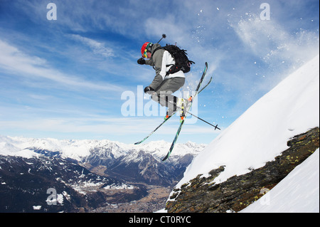 Skier Jumping off pente enneigée Banque D'Images