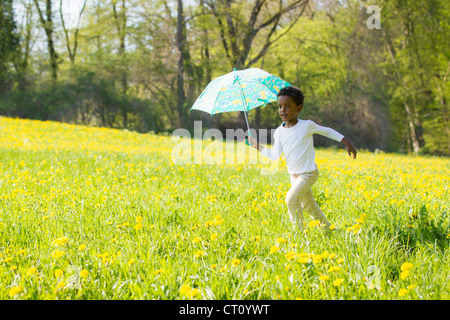 Boy carrying parapluie dans domaine Banque D'Images