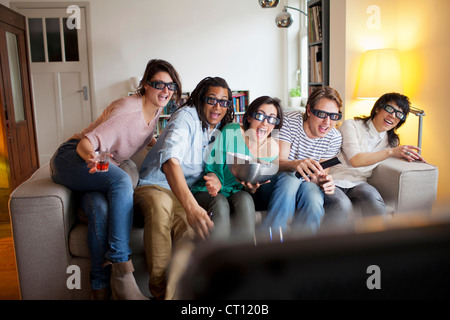 Friends watching movie in living room Banque D'Images