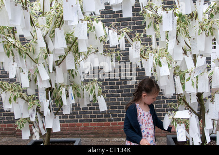 Serpentine Gallery - arbre des désirs par Yoko Ono - enfant l'examen des étiquettes avec des souhaits écrits sur eux