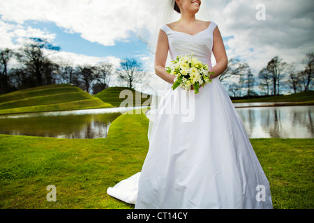 Smiling bride walking in field Banque D'Images