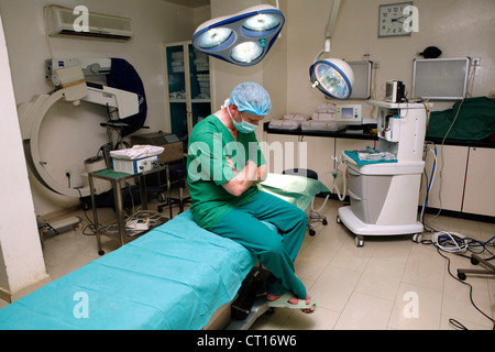 Un chirurgien fatigué dort se trouve sur la table et pose de théâtre. Banque D'Images