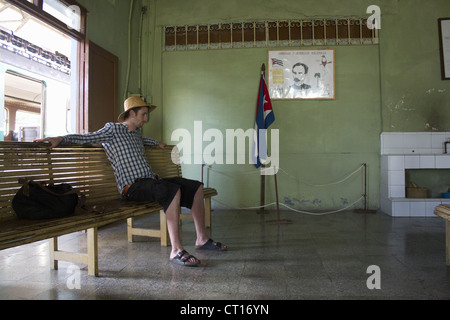 Homme assis sur le banc en bois dans le hall. Banque D'Images