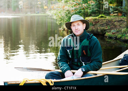 Homme assis en canoë sur le lac encore Banque D'Images