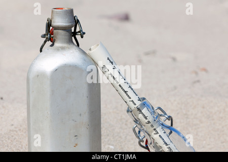 Une cantine et une bouteille sont dans le sable du désert Banque D'Images