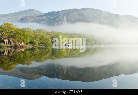 Montagnes au-dessus d'une côte bordée de misty sur Llyn Dinas Lake dans le Parc National de Snowdonia Nantgwynant Valley North Wales Banque D'Images