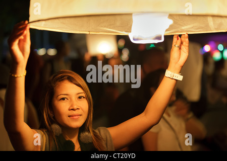 Femme thaïlandaise lancement fire lantern durant Loi Krathong festival bouddhiste de Chiang Mai, Thaïlande Banque D'Images