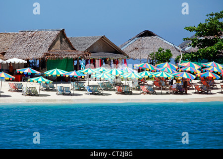 Transats et parasols colorés pour des vacances d'été sur la plage de sable tropicale de Khai Nai, Phuket, Thailand Banque D'Images