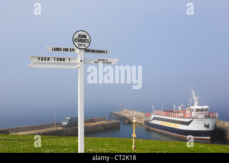 Scène avec panneau et ferry avec sea mist sur la côte nord-est à John O' Groats Caithness Scotland UK en Grande-Bretagne. Banque D'Images