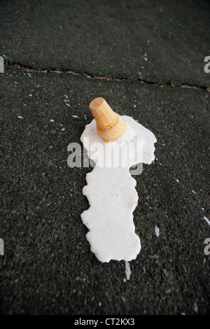 Un cornet de crème glacée fondre sur la chaussée chaud. Banque D'Images