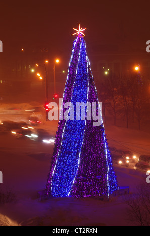 L'extérieur de l'arbre de Noël décoré avec des lumières à l'hiver dans la rue Yuzhno-Sakhalinsk, l'île de Sakhaline, en Russie extrême-orient Banque D'Images