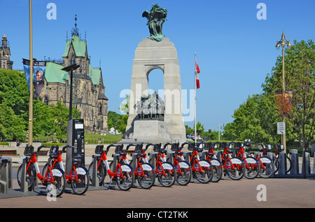 Location de bicyclettes à Ottawa, Ontario, Canada. Dans l'arrière-plan est le monument commémoratif de guerre du Canada. Banque D'Images