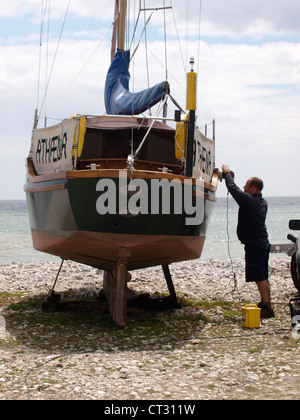 Menuiserie ponçage homme sur un yacht, Lyme Regis, dans le Dorset, UK Banque D'Images