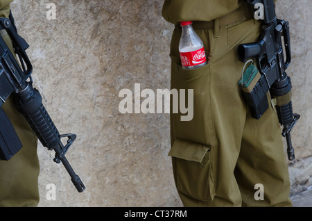 Gros plan d'une bouteille de coca cola dans un soldat israélien a pockest avec armes à feu. Mur ouest. Vieille ville de Jérusalem. Israël. Banque D'Images