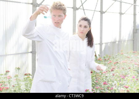 Les scientifiques examinant liquid in beaker Banque D'Images