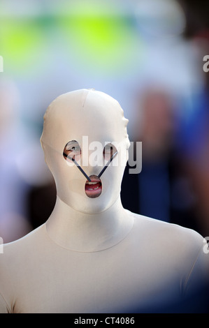 Jeune homme portant un étrange masque et costume morph farfelus sur le visage à l'événement de sports de plein air, promenade Sussex UK Banque D'Images