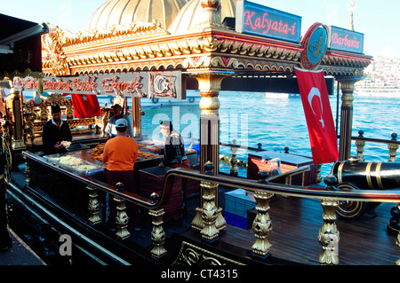 La Turquie, Istanbul, Eminoenue, corne d'or, le poisson à manger des sandwichs à la vente du poisson sur un bateau d'or richement décoré Banque D'Images