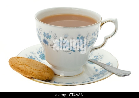 Une tasse de thé chaud servi dans une tasse et soucoupe à motifs avec un biscuit - studio shot. Banque D'Images