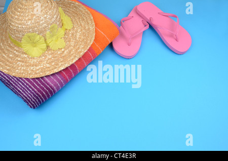 Concept d'été libre de droit d'une douce serviette de plage colorée rose avec des tongs et un chapeau de paille Banque D'Images