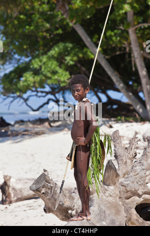 L'Indonésie, la Papouasie-Nouvelle-Guinée, Nuana Island. Jeune garçon en costume traditionnel de pêche sur la plage. Banque D'Images