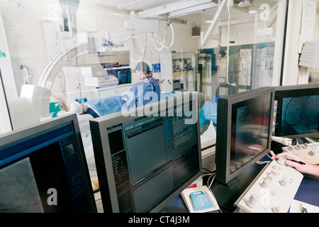 Cathlab dans l'hôpital moderne avec médecin, infirmière et patient Banque D'Images