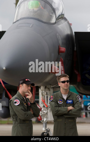 Deux équipages de l'US Air Force se tenir ci-dessous le nez de leur avion de chasse F-16C au Farnborough Air Show, au Royaume-Uni. Banque D'Images