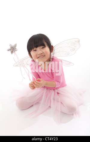 Une jeune fille portant un tutu rose et les ailes de papillon tourné en studio sur un fond blanc. Banque D'Images