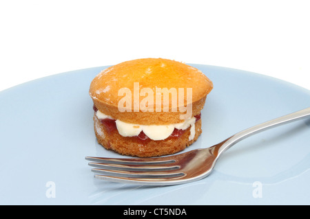 Mini victoria sponge cake sur une plaque bleue avec une fourchette Banque D'Images