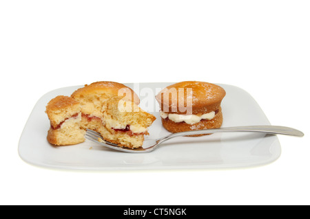 Mini victoria sponge cakes sur une assiette avec une fourchette isolés contre white Banque D'Images