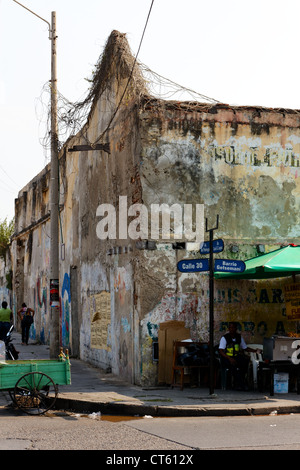 Coin de rue avec les fournisseurs et un bâtiment abandonné à Cartagena de Indias, Colombie. Banque D'Images