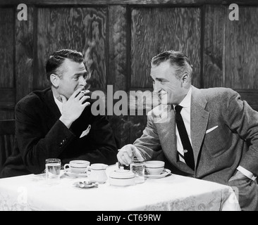 Hommes d'fumer des cigarettes et en souriant le dîner Banque D'Images