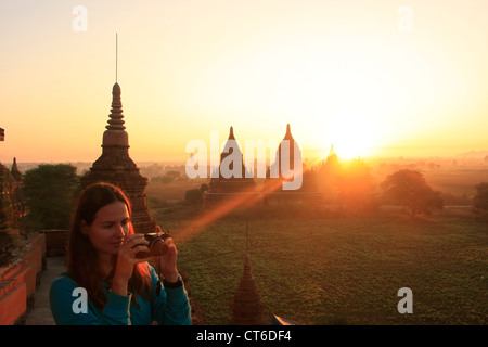 Woman photographing temples au lever du soleil, Zone Archéologique de Bagan, Mandalay, Myanmar, région Asie du sud-est Banque D'Images