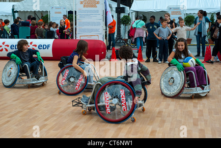 Paris, FRANCE - foule nombreuse, public sportif athlètes français handicapés enseignant aux enfants en fauteuil roulant, cours de basket-ball aux rencontres EDF Handispor. exercice sur les besoins spéciaux Banque D'Images