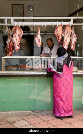 Une femme arabe shopping pour la viande d'un boucher, le souk, la médina, Taroudant, Maroc Sud Banque D'Images