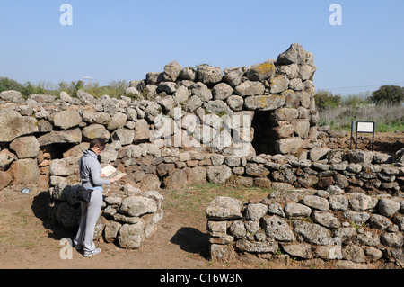 Un touriste se penche sur les ruines de la Nuraghe Losa, Sardaigne, Italie Banque D'Images