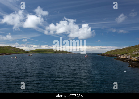 Île de Barra, Ecosse. Vue pittoresque sur les bateaux de pêche ancrés à Caolas Bhatarsaigh Vatersay inlet avec en arrière-plan. Banque D'Images